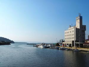a river with boats docked next to a building at 大村ヤスダオーシャンホテル in Omura