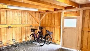 twee fietsen staan geparkeerd in een houten garage bij KrabatResidenz - Apartmenthaus in Burg