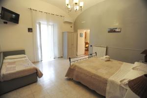 1 dormitorio con 2 camas y lámpara de araña en Villa Flora, en Pompeya