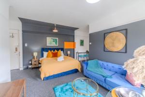 布萊頓霍夫的住宿－Sea View I Central Brighton Location I Sleep 3 I Next to Brighton Beach，一间卧室配有一张床和一张蓝色的沙发