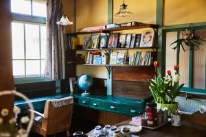 une chambre avec une table et une étagère avec des livres dans l'établissement ソルトハウス, à Imabari
