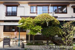 un bâtiment avec une table et des arbres devant lui dans l'établissement ソルトハウス, à Imabari