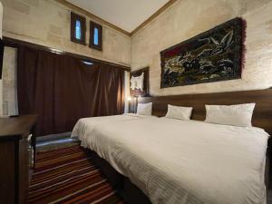 um quarto de hotel com uma cama grande e uma janela em lariva konakları em Şanlıurfa