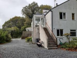 een huis met een trap en een bank ernaast bij Miterdale A Wonderful Home in the Idyllic Duddon Valley in Broughton in Furness