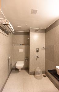 a bathroom with a toilet and a sink at Hotel Mangala Temple View in Guruvāyūr
