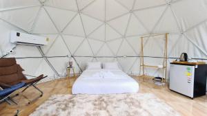 a bedroom with a bed in a tent at Greatland Glamping Khao Yai Resort in Ban Khanong Phra Tai