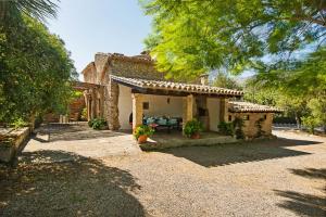 a stone house with a porch and a patio at El Rafalet in Pollença