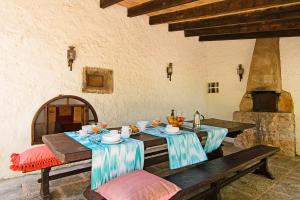 a dining room with a table and chairs and a stone oven at El Rafalet in Pollença
