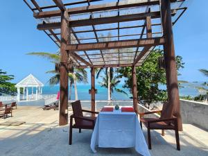 a table and chairs on a patio with the beach at Bhundhari Resort & Villas Samui in Chaweng