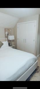 a bedroom with a white bed and a white cabinet at Luxury HomeStays - Hot Tub - Sea Views - Sleeps 8 in Portsmouth