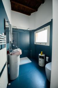 a blue bathroom with a sink and a toilet at PINK HOUSE TORTELLINOSUITE Modena in Modena