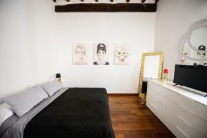 a bedroom with a bed and a flat screen tv at PINK HOUSE TORTELLINOSUITE Modena in Modena