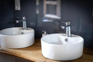 a bathroom with two sinks on a wooden counter at Le Pied de la Lettre in Grignan