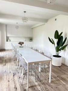 - une salle à manger blanche avec une table et des chaises blanches dans l'établissement Rezydencja Leśniów, à Żarki