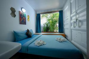 una camera da letto con un letto blu e una finestra di White Rabbit Hostel a Siem Reap