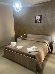 a bedroom with a large bed with towels on it at Casa Vacanza Merguli d'Oro in Siculiana +20 photos