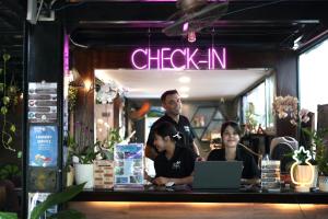 a man and two women sitting at a counter with a laptop at Rom Casa Hostel Da Nang in Da Nang