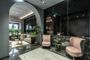 eine Lobby eines Hotels mit Stühlen und Pflanzen in der Unterkunft CC Palace Hotel in Rom