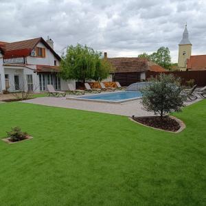 einen Hof mit einem Pool und einem Haus in der Unterkunft Klára-Háza Vendégház in Tiszadorogma