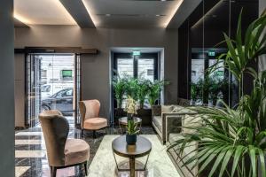 een lobby met stoelen en een tafel en planten bij CC Palace Hotel in Rome