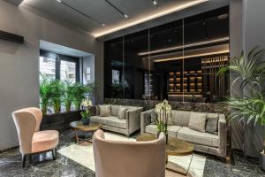 a lobby with couches and tables and potted plants at CC Palace Hotel in Rome