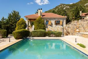 a house with a swimming pool in front of a house at Pleiades All Season Gems - Korinthos Stone Retreats in Kalianoi