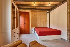 a bedroom with a red bed and a couch at Rote Wohnung - Ferienwohnung (Goldenes-Häusle) in Sulzbach an der Murr