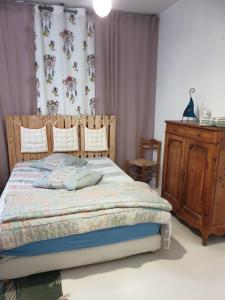 a bedroom with a bed and a wooden dresser at La Demeure in Gabarret