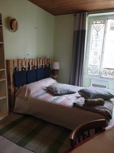 a bedroom with a large bed with a window at La Demeure in Gabarret