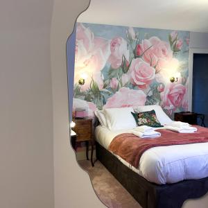 1 dormitorio con 1 cama con pared de flores en La Demeure d'Élodie, en Épernay