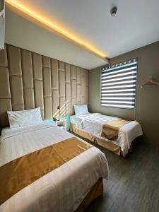 ein Hotelzimmer mit 2 Betten und einem Fenster in der Unterkunft Felicity Island Hotel in Mactan