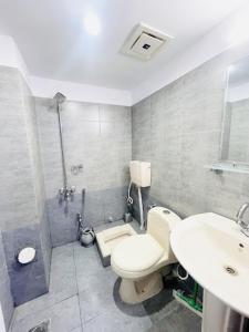 y baño con aseo, lavabo y ducha. en Moven Inn Hotel Islamabad en Islamabad