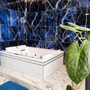 a bath tub in a bathroom with blue tiles at La Demeure d'Élodie in Épernay