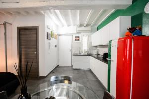 a kitchen with a red refrigerator and white cabinets at ITALIA HOUSE TORTELLINOSUITE Modena in Modena +8 photos