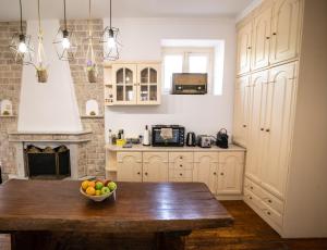 a kitchen with a bowl of fruit on a wooden table at Apeiron Acropolis Suites in Athens