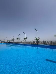uma grande piscina azul com palmeiras ao fundo em Central Gwangju Hotel & Residence em Gwangju