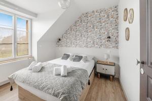 una camera bianca con due letti e una finestra di LA BAIE - Belle maison de charme -Jardin/Parking a Cancale