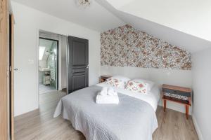 カンカルにあるLA BAIE - Belle maison de charme -Jardin/Parkingの白いベッドと壁が備わるベッドルーム1室が備わります。