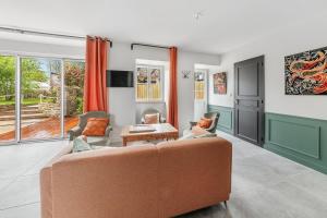 un soggiorno con divano e tavolo di LA BAIE - Belle maison de charme -Jardin/Parking a Cancale