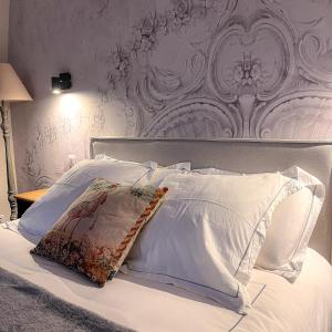 a white bed with a white headboard and white pillows at La Demeure d'Élodie in Épernay