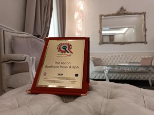 a red framed sign sitting on top of a bed at The Moon Boutique Hotel & Spa in Florence