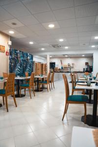 una sala da pranzo con tavoli e sedie in legno di Hotel Del Corso a Bibione