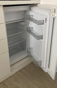 an empty refrigerator with its door open in a kitchen at Apartman Senjak in Pirot