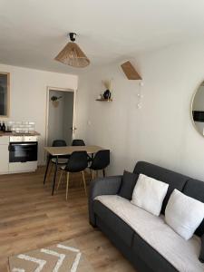 een woonkamer met een bank en een tafel bij BERCK sur Mer Appartement Cosy à 50 métres de la plage in Berck-sur-Mer
