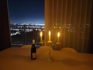 a table with a bottle of wine and two candles at Lovely House in Incheon