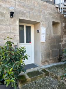 a white door on a stone building with a plant at Rote Wohnung - Ferienwohnung (Goldenes-Häusle) in Sulzbach an der Murr