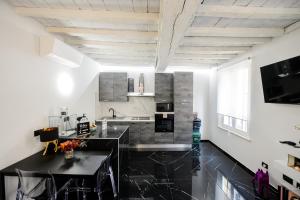 a kitchen with a black counter top in a room at URBAN JUNGLE TORTELLINOSUITE Modena in Modena