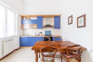 eine Küche mit blauen Schränken und einem Holztisch in der Unterkunft La mia casetta al mare! (011017-LT-0766) in Levanto