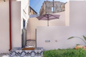 an umbrella on the side of a white building at Camara Residence in Chania