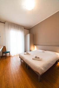 een slaapkamer met een groot bed met twee handdoeken erop bij Hotel Del Corso in Bibione